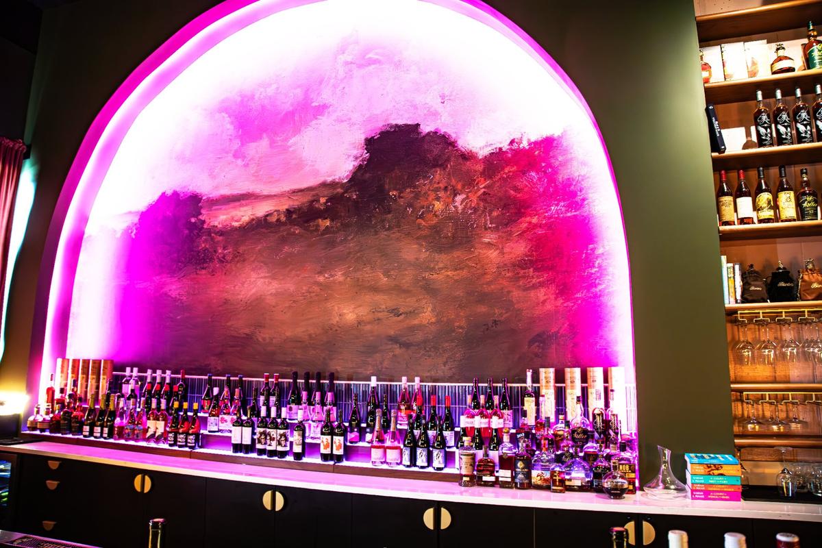 A hand-painted surreal mural teleports customers to the rural countryside at the new speakeasy located inside District 7 Social in Lexington’s Distillery District, called Book Club Wine Room at 1170 Manchester St #160 on May 23, 2025, in Lexington, Ky.