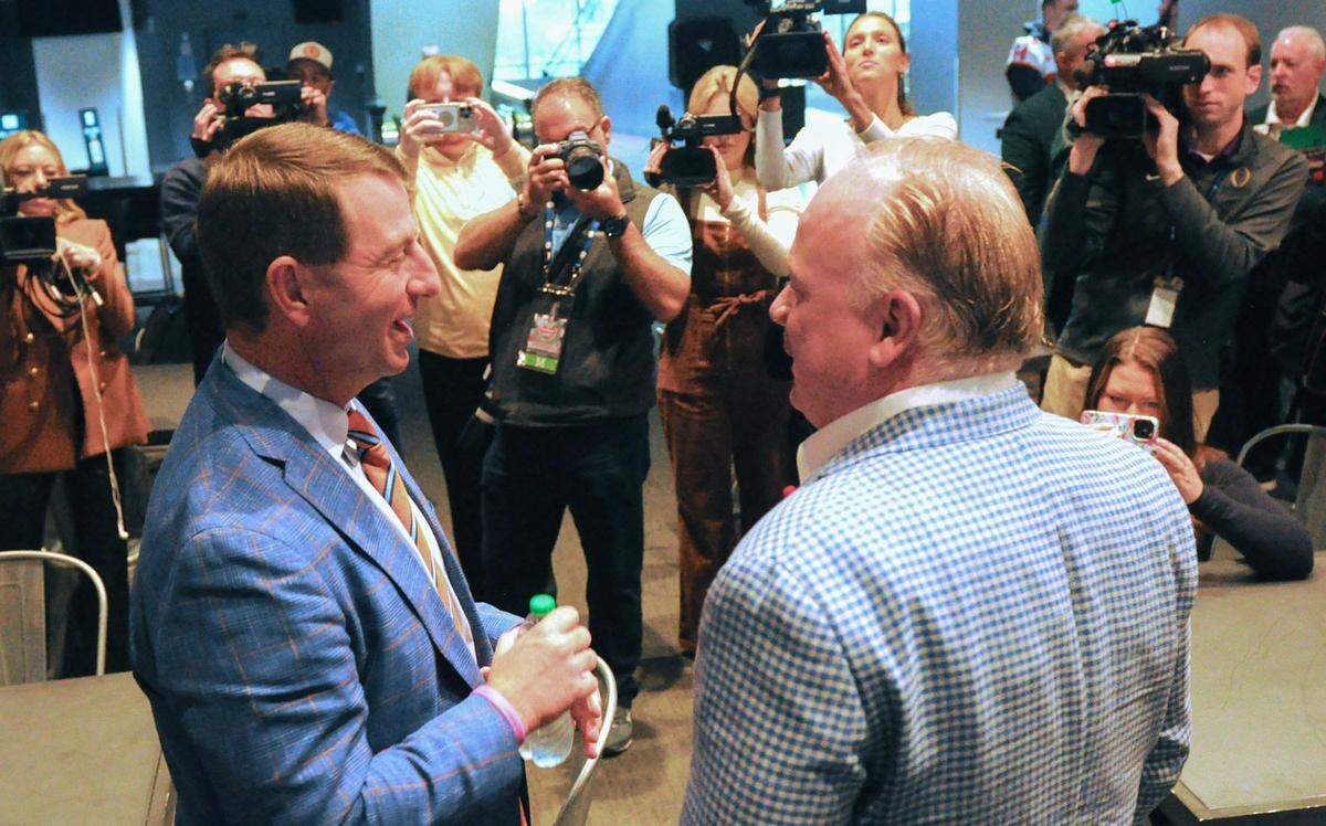 Clemson head coach Dabo Swinney and Kentucky head coach Mark Stoops meet at the pre-Gator Bowl press conference in Jacksonville, Florida, last season. The two are among the most long-tenured coaches in all of college football.