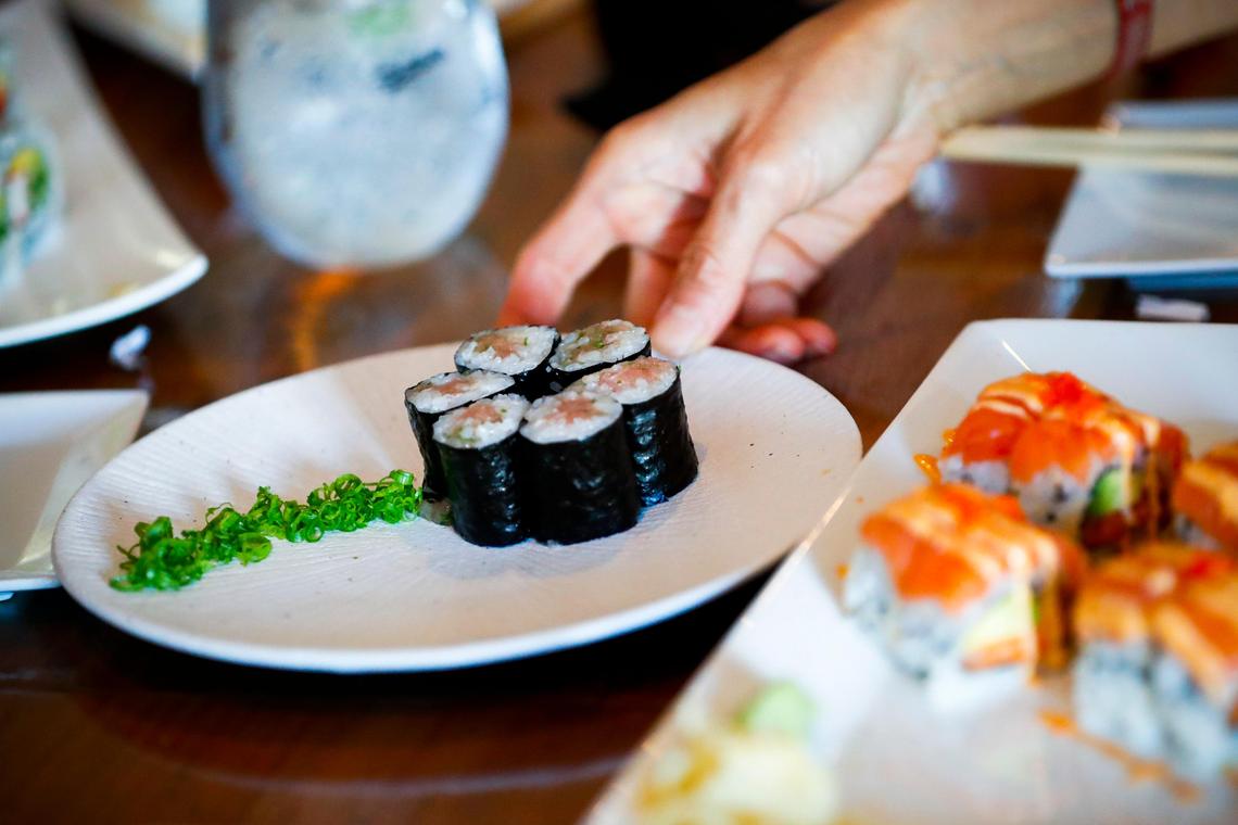 Hui-Nee See Tyler, of Lexington, Ky., reaches for sushi roll at Zen Sushi & Sake in Lexington, Friday July 26, 2019. Over the past year the Tyler family have been eating “alphabet dinners” choosing restaurants from a-z staring with Asian Wind and ending with Zen Sushi & Sake.