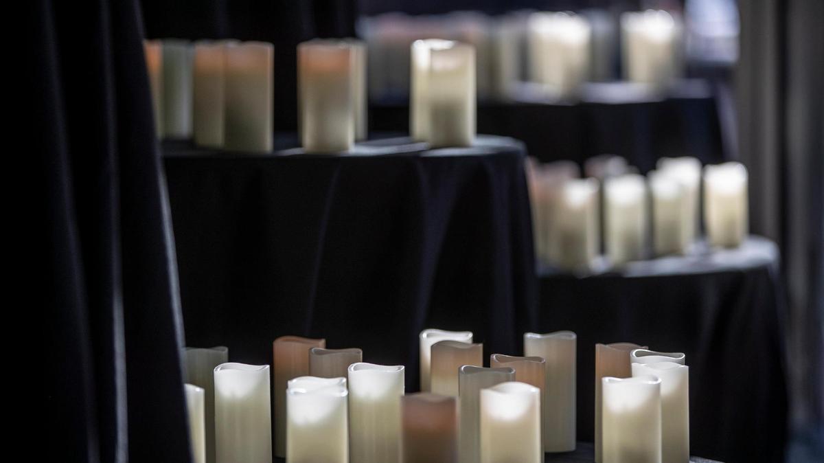 Candles in honor of COVID-19 victims are in the windows at the Pam Miller Downtown Arts Center in Lexington, Ky., on Friday, Nov. 20, 2020. Mayor Linda Gorton and several members of the faith community held a memorial in honor of the 106 people in Lexington who have lost their lives to the coronavirus since the start of the pandemic.