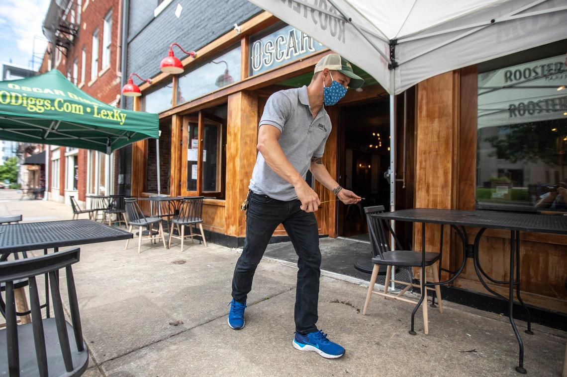 Vince Grupposo, Oscar Diggs CFO, uses a measuring tape to ensure outdoor tables are safely spaced at the restaurant in Lexington, Ky., on Friday, May 22, 2020, so the restaurant could reopen to diners during the early days of the pandemic.