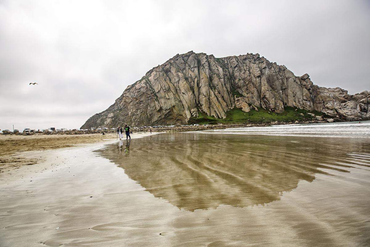 Morro Rock is reflected on the wet sand in 2015 in Morro Bay, Calif.