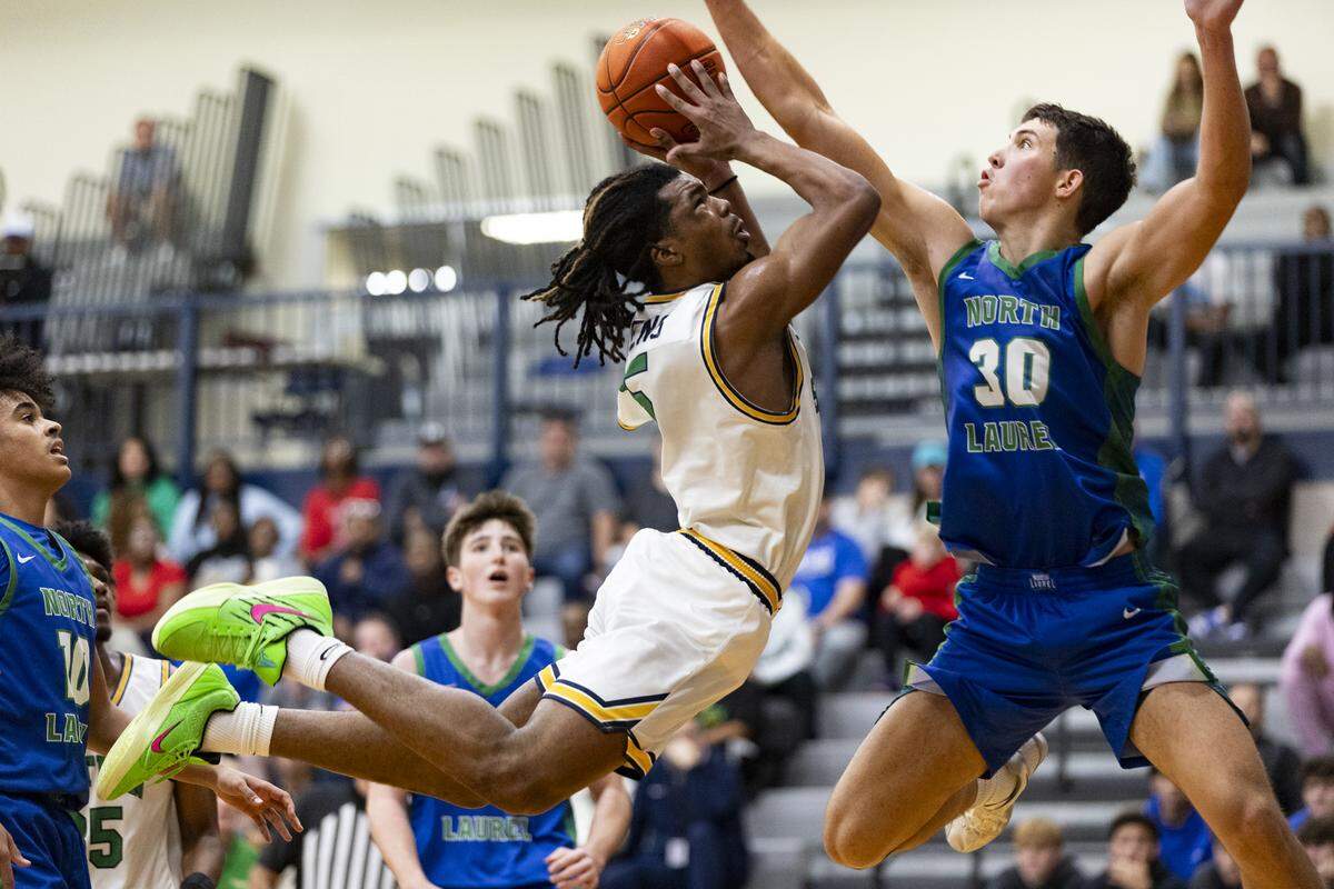 Bryan Station’s Amari Owens (5) drove into the lane against North Laurel’s Reece Davidson and drew a foul during the second half of the Jaguars’ 55-52 win over the Defenders in the White, Greer & Maggard Holiday Classic at Lexington Catholic High School on Sunday.
