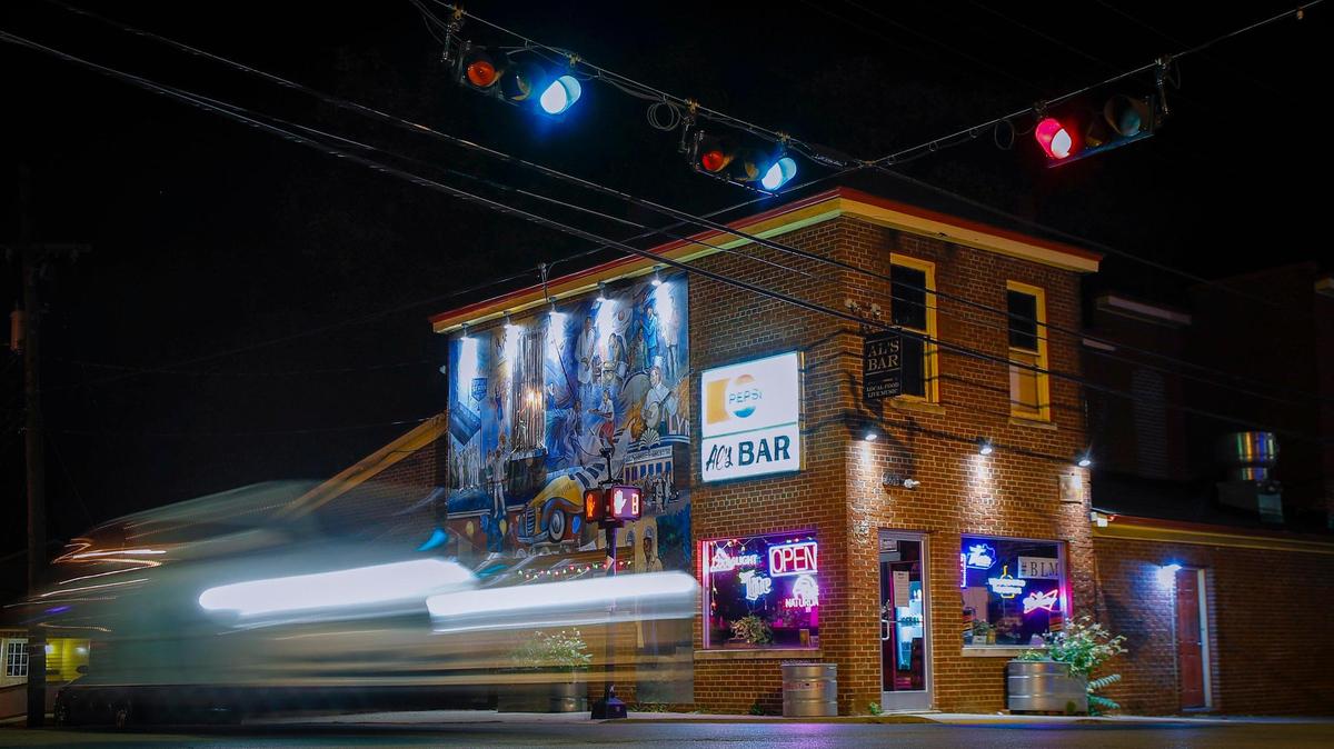 A car streaks past Al’s Bar at the corner of East Fifth Street and North Limestone Road in Lexington, Ky., Wednesday, Oct. 14, 2020.