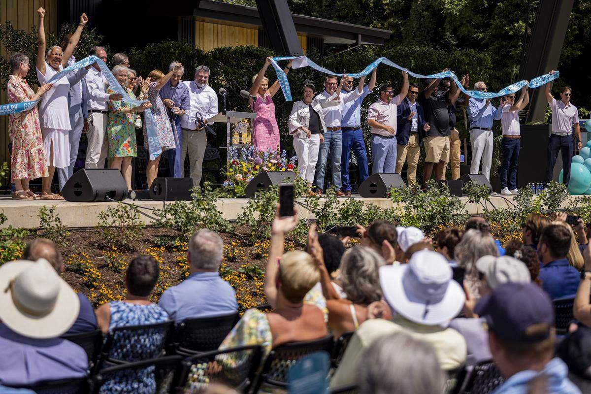 People cheer as the ribbon is cut during the opening of Gatton Park on Saturday, Aug. 23, 2025, in Lexington, Ky. 