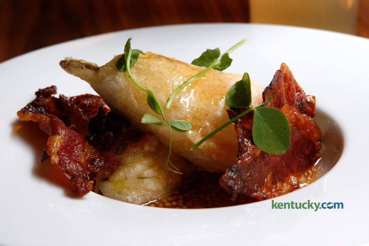 Chef Mark Wombles drizzles honey over goat cheese squash blossoms with peach mostarda and house Guanciale June 30, 2015 at Distilled at Gratz Park Inn.