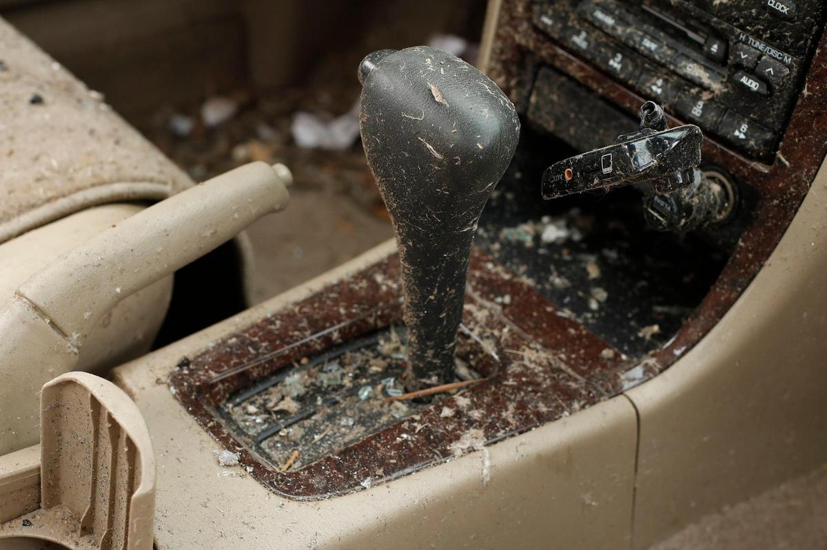 Debris covers the interior of a Nissan sedan parked near a destroyed home along North 6th street in Mayfield, Ky., Wednesday, Dec. 15, 2021.