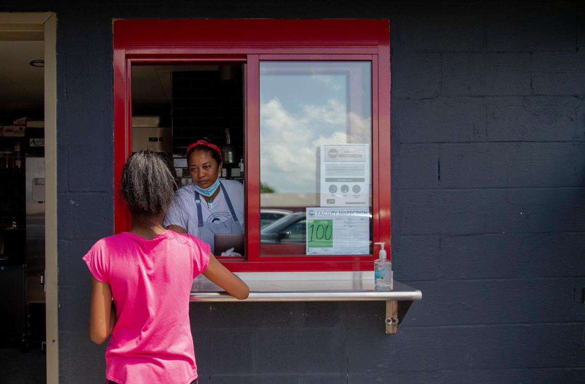 Chef and owner Tonya Mays-Cronin speaks with her daughter at the pick-up window at the new Kismet at The Burl restaurant in the Distillery District, which opened the evening of June 10, 2020.