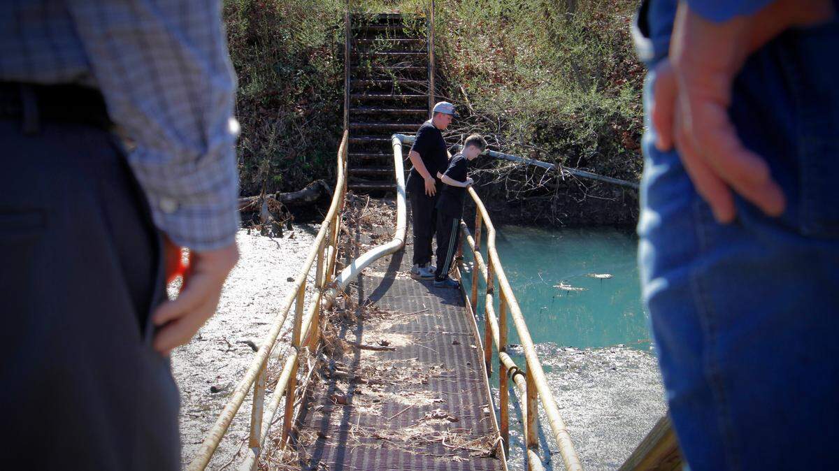 Noah Kiser, 10, right, and Jase Hickerson, 12, stare down from atop a catwalk into a flooded mine shaft entrance where their great-uncle Kenneth Kiser, a federal mine safety inspector, died nearly 50 years ago. The boys attended a memorial as the former mine March 9, 2026.