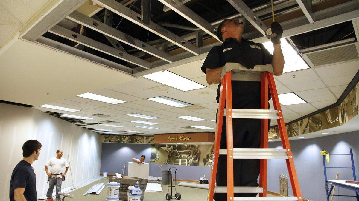 Steve Davis, right, of Landmark Sprinkler, took  measurements Friday at Joseph-Beth in the area that used to house music. The area will be the travel section of the store. The store in Lexington Green is undergoing an extensive renovation but will remain open during the process.  