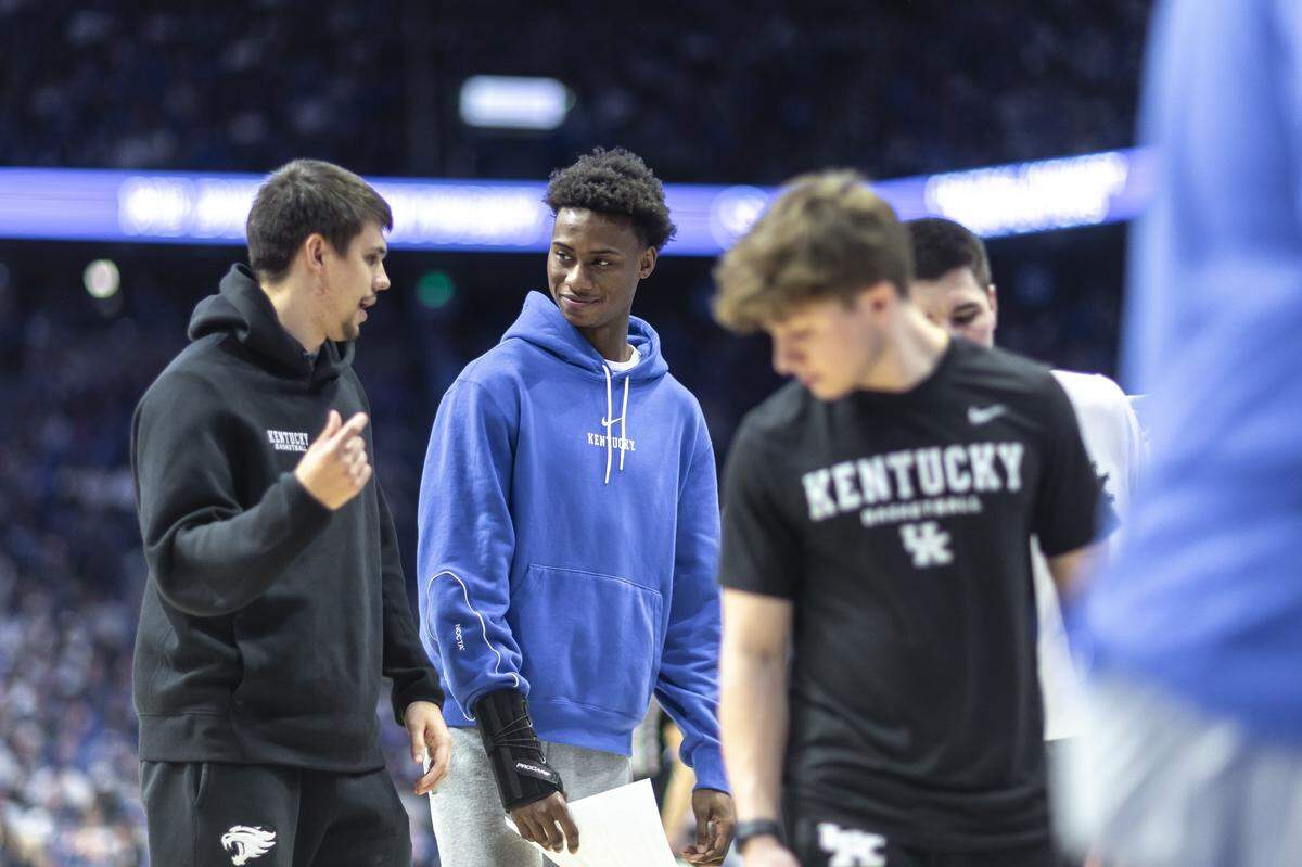 Kentucky guard Jaxson Robinson, center, talks with teammate Kerr Kriisa, left, before a game in Rupp Arena earlier this month. Both have been sidelined with injuries, but Robinson is probable to return Wednesday night.