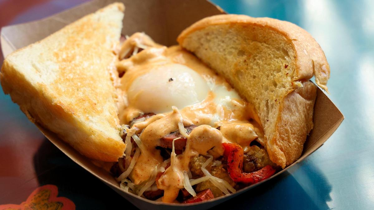 A Breakfast Reuben ($9.75) from DV8 Kitchen, made with corned beef, potatoes, bell peppers, Swiss cheese, sauerkraut, Russian dressing, topped with a poached egg and served with toast.