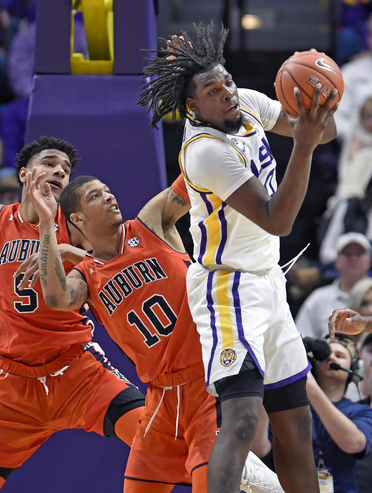 LSU’s Naz Reid, right, pulled down an offensive rebound in front of Auburn’s Samir Doughty (10) and Chuma Okeke (5) on Saturday.