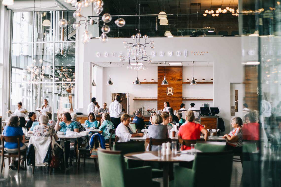 The dining room at Bottle & Bond at Bardstown Bourbon Company features floor-to-ceiling windows and glass globe chandeliers.