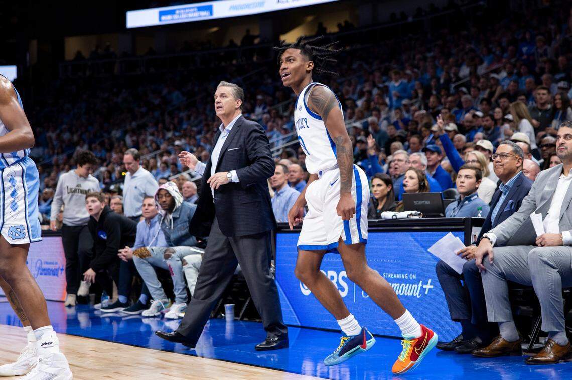 Rob Dillingham celebrates a 3-pointer as John Calipari watches and former Kentucky guard John Wall sits courtside for the Wildcats’ 87-83 win over North Carolina on Saturday night.