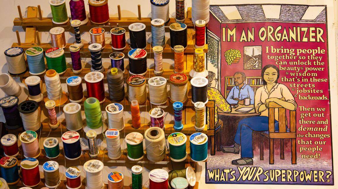 An assortment of thread spools on display next to an organizing pamphlet, in the small home studio of local artist and activist fashion designer, Soreyda Benedit Begley, on Jan. 21, 2026, in Lexington, Ky.
