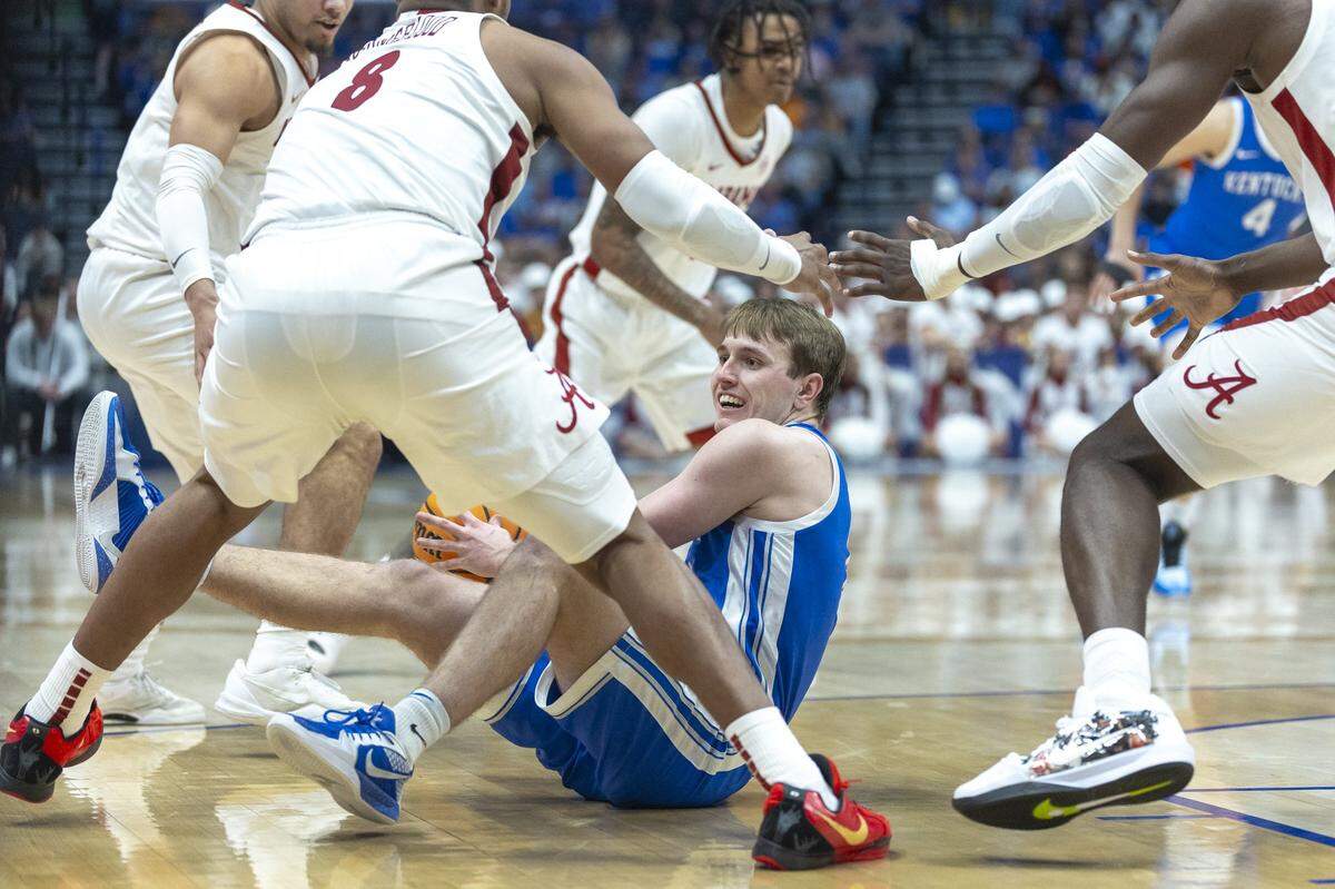 Kentucky guard Travis Perry (11) is surrounded by Alabama defenders, including Crimson Tide guard Chris Youngblood (8), during Friday’s SEC Tournament game at Bridgestone Arena in Nashville, Tennessee.