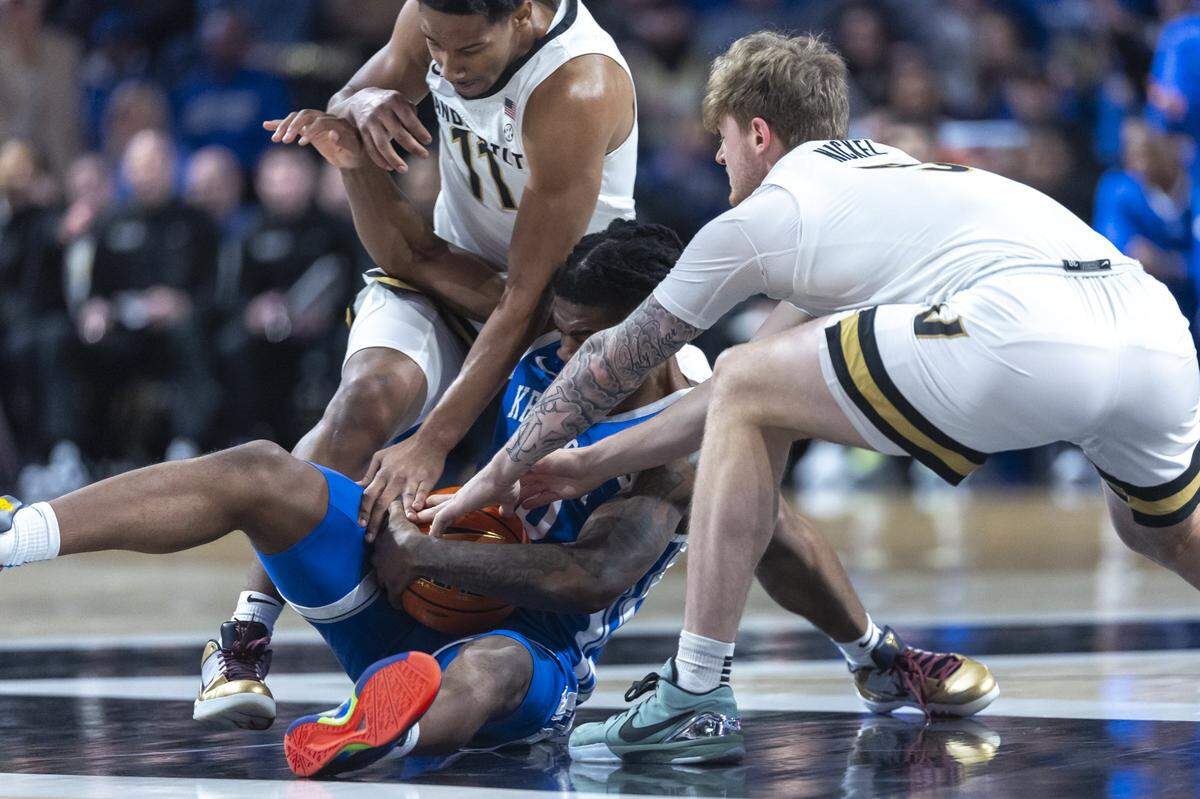Kentucky guard Otega Oweh battles for the ball with Vanderbilt guards AJ Hoggard, left, and Tyler Nickel (5) during Saturdays game at Memorial Gymnasium in Nashville, Tennessee.