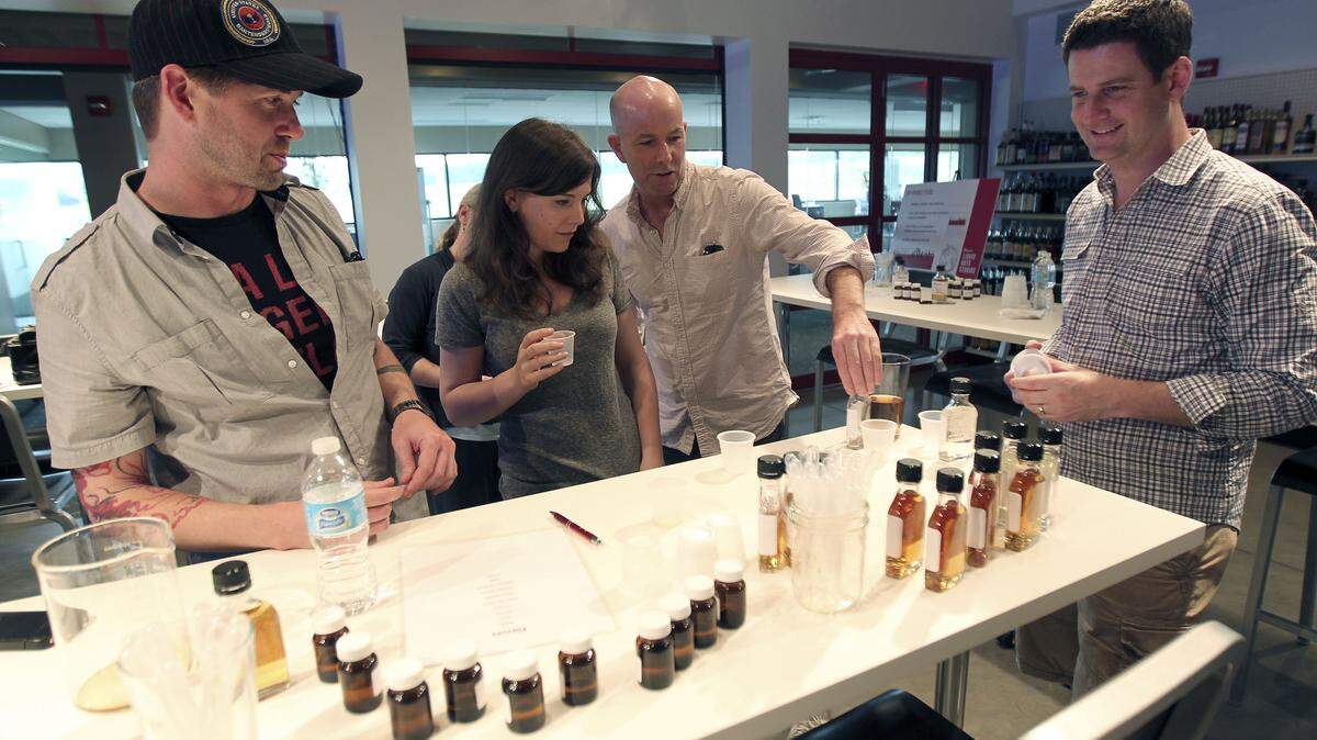 Guests at the Beam Global Innovation Center, from left, mixologist Tony Devencenzi, journalists Carey Jones and Jason Rowan and Alex Abraham of Edelman Public Relations, created various flavored bourbons to try during a tour of the Clermont facility June 17.