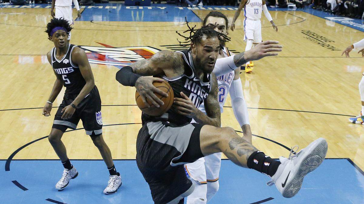 Sacramento Kings center Willie Cauley-Stein (00) grabs a rebound in front of Oklahoma City Thunder center Steven Adams (12) during an NBA basketball game in Oklahoma City, Saturday, Feb. 23, 2019.