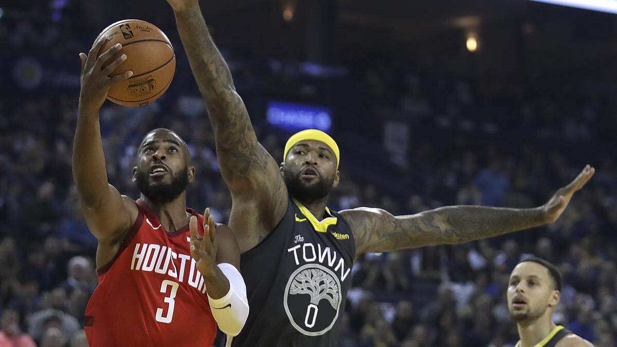 The Houston Rockets’ Chris Paul, left, got to the basket against the Golden State Warriors’ DeMarcus Cousins on Saturday.