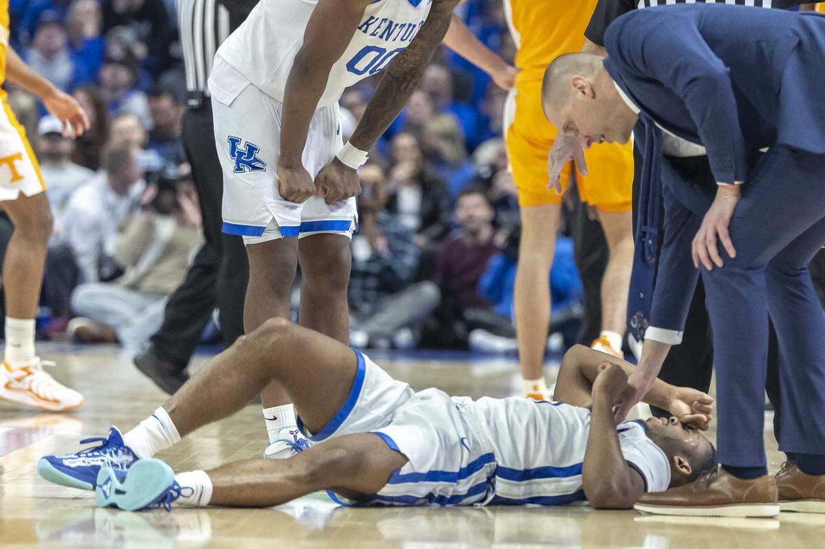 Kentucky head coach Mark Pope checks on point guard Lamont Butler after he was injured during Tuesday’s game against Tennessee.