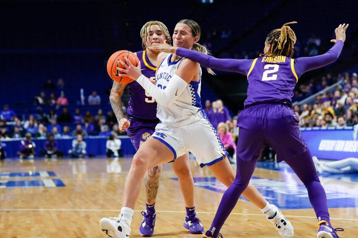 Kentucky guard Maddie Scherr, center, tries to get to the basket while defended by LSU guard Jasmine Carson (2) during Sunday’s game at Rupp Arena.