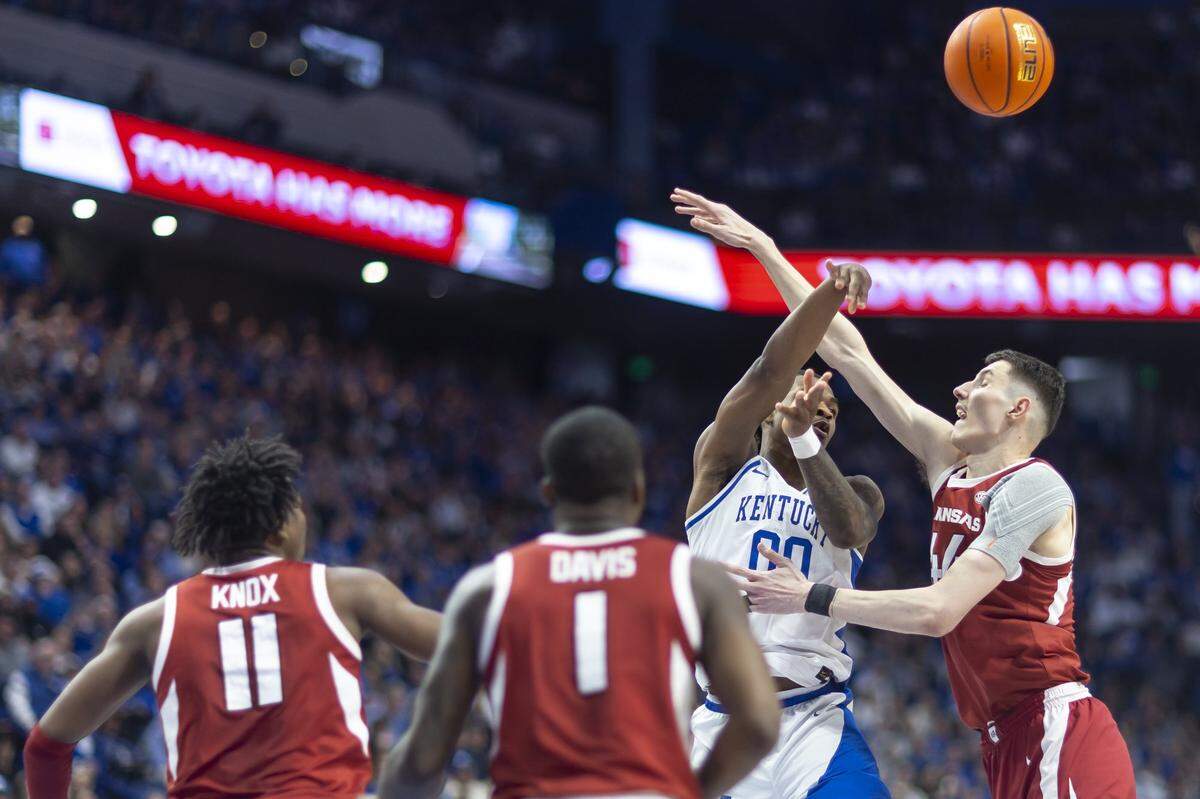 Kentucky guard Otega Oweh (00) tries to pass the ball past Arkansas forward Zvonimir Ivisic (44) during Saturday’s game at Rupp Arena.