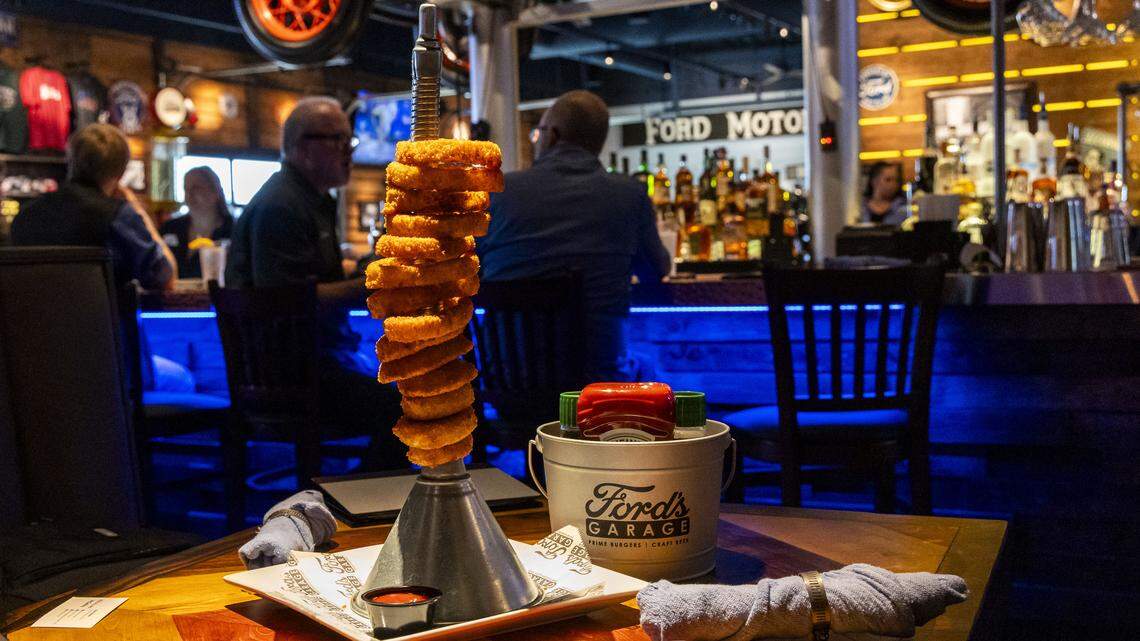 The popular Giant Funnel Tower of Piston Onion Rings appetizer ($12.99) at Ford’s Garage, photographed Tuesday, Nov. 4, 2025 in Lexington, Ky., is served with house-made chipotle ketchup and Hidden Valley Ranch.