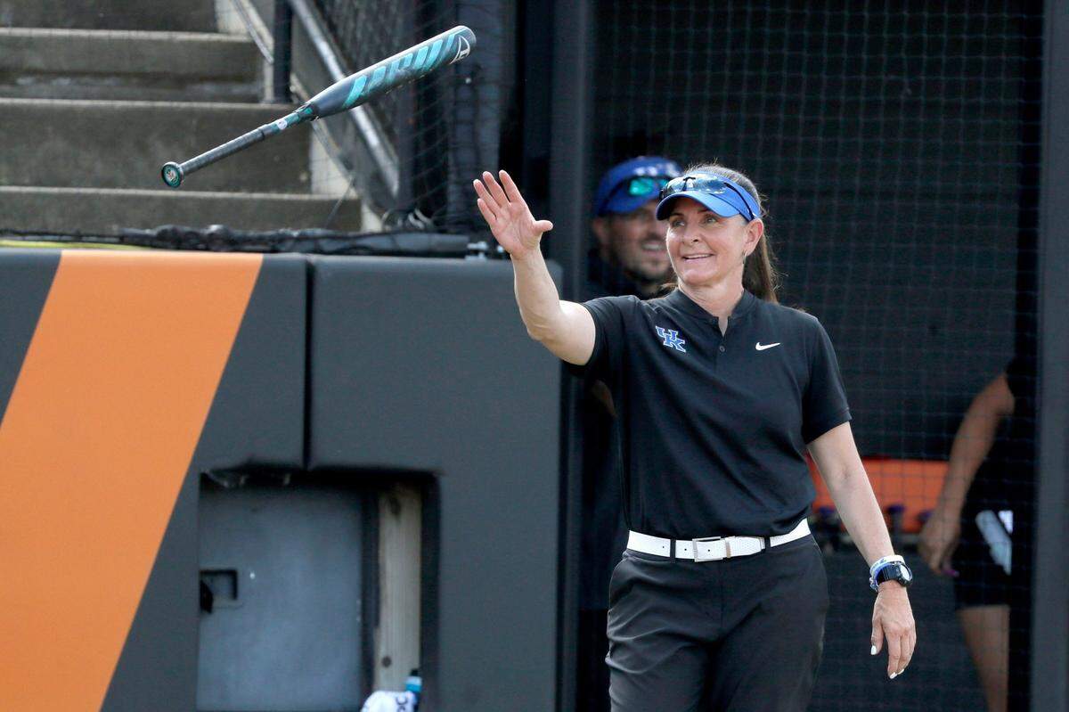 Kentucky coach Rachel Lawson catches a bat during a softball game against Michigan in the first round of the Stillwater Regional of the NCAA Tournament in Stillwater, Okla., Friday, May 17, 2024.