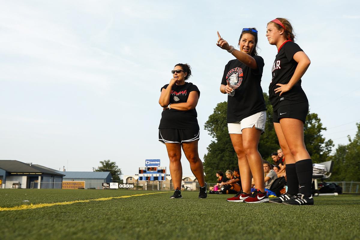 Paul Laurence Dunbar girls’ soccer head coach Megan Poage, center, instructed Alison O’Hara as she was about to be subbed in during their game against Madison Southern on Tuesday in the Fayette County Soccer Spectacular at Henry Clay High School. At left was goalie coach Caitlin Wohlander. Another assistant, Arly Lankster, was leading junior varsity practice back on campus.
