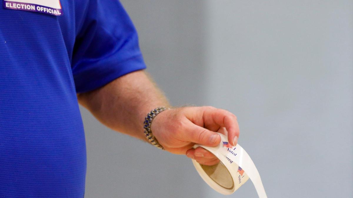 A Kirklevington precinct worker hands out “I voted” stickers to voters during the 2023 statewide general election at the Kirklevington precinct at Tates Creek Middle School, Tuesday, November 7, 2023 in Lexington, Ky.