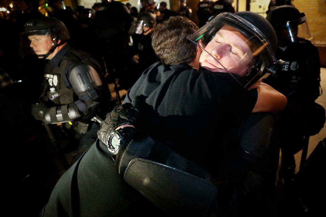 Qina Morones, of Lexington, Ky, left, hugs Lexington police officer Cody McMillen in front of the Lexington Police Department during the third night of protests in downtown Lexington, Ky., Sunday, May 31, 2020. The protests come amid a nationwide outcry over the deaths of George Floyd in Minneapolis and Breonna Taylor in Louisville, who both died at the hands of police.