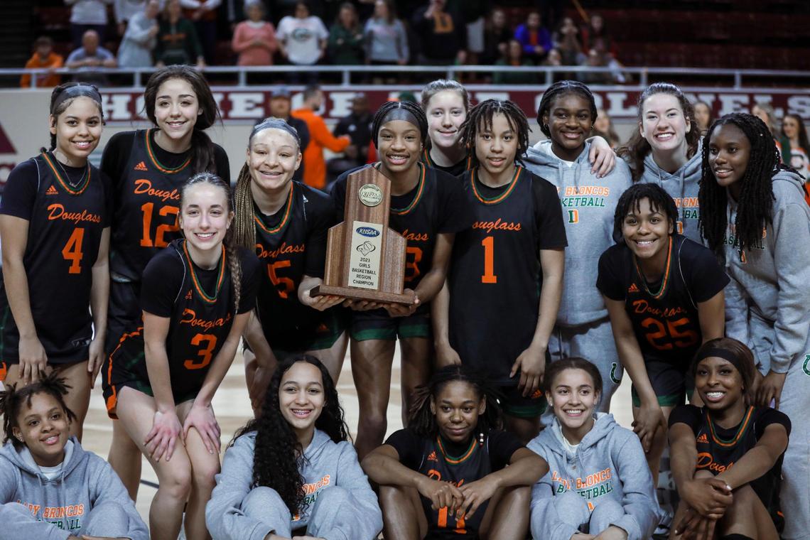 The Frederick Douglass Broncos, including MVP Ayanna Darrington (bottom right), celebrate winning the 11th Region Tournament championship game against Lexington Catholic in Richmond on Saturday.