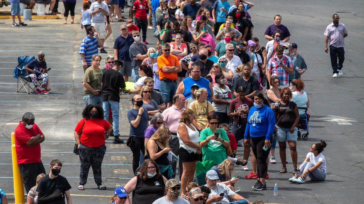 Hundreds of people wait in line for assistance with their unemployment benefits outside the Kentucky state Capitol in Frankfort, Ky., on Wednesday, June 17, 2020.