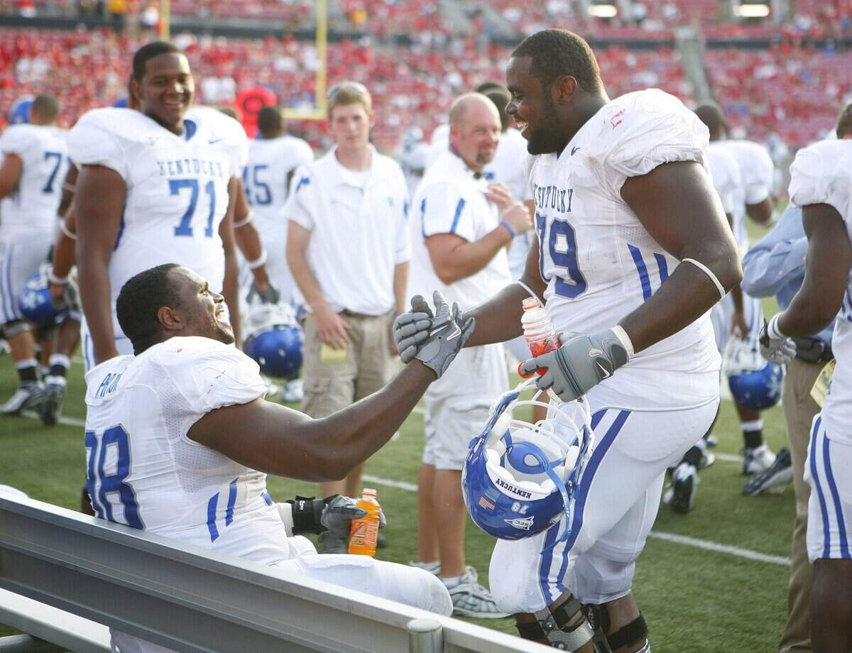 Kentucky defensive tackle Myron Pryor, left, accepted congratulations from offensive lineman Garry Williams after Pryor returned a fumble 72 yards for a touchdown in UK’s 27-2 victory over Louisville in the 2008 season opener.