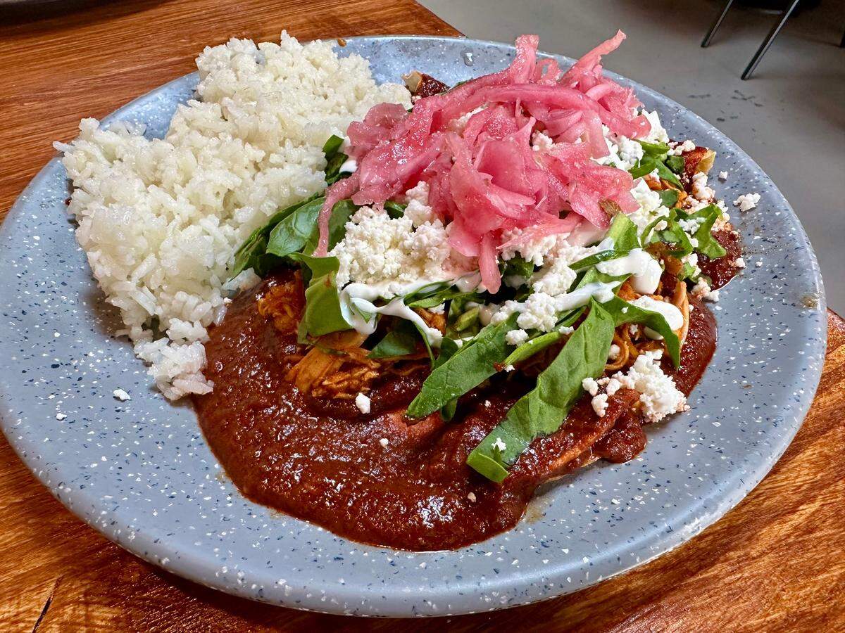 Chicken enchiladas with rice at Mazunte Bodega, a popular Cincinnati Mexican restaurant and bodega which opened a location in Lexington’s Distillery District next to the new Manchester Hotel.