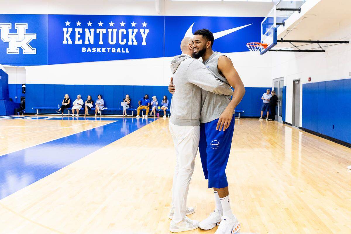 Former Kentucky star Karl-Anthony Towns, right, gets a hug from UK coach Mark Pope during the NBA player’s visit with the team ahead of Friday night’s UK Athletics Hall of Fame induction ceremony.