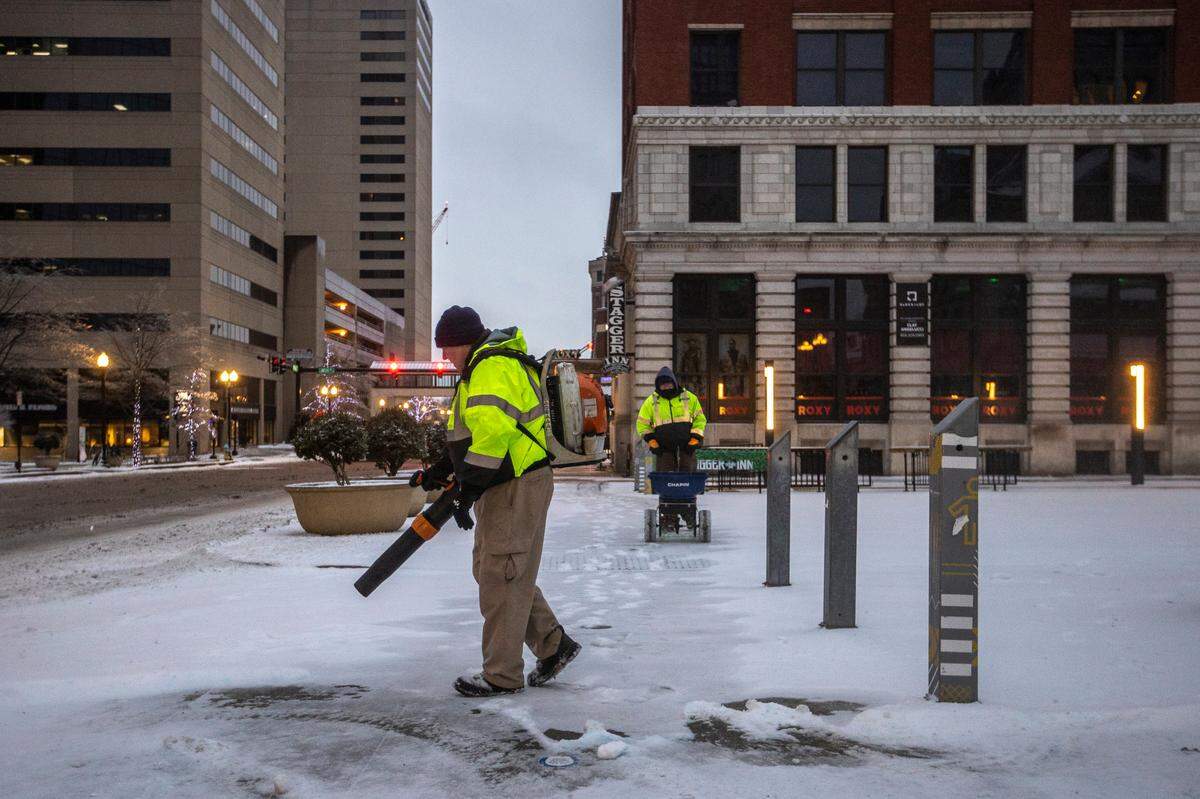 Bobby Craig, left, and Jesse Henderson, both with Lexington’s Parks and Recreation Department, clear snow and ice from near Henry A. Tandy Centennial Park in downtown Lexington, Ky., on Monday, Feb. 15, 2021. The park usually hosts Lexington Farmers Market on Saturdays even in the winter. But the market will be moving indoors briefly in January 2025.