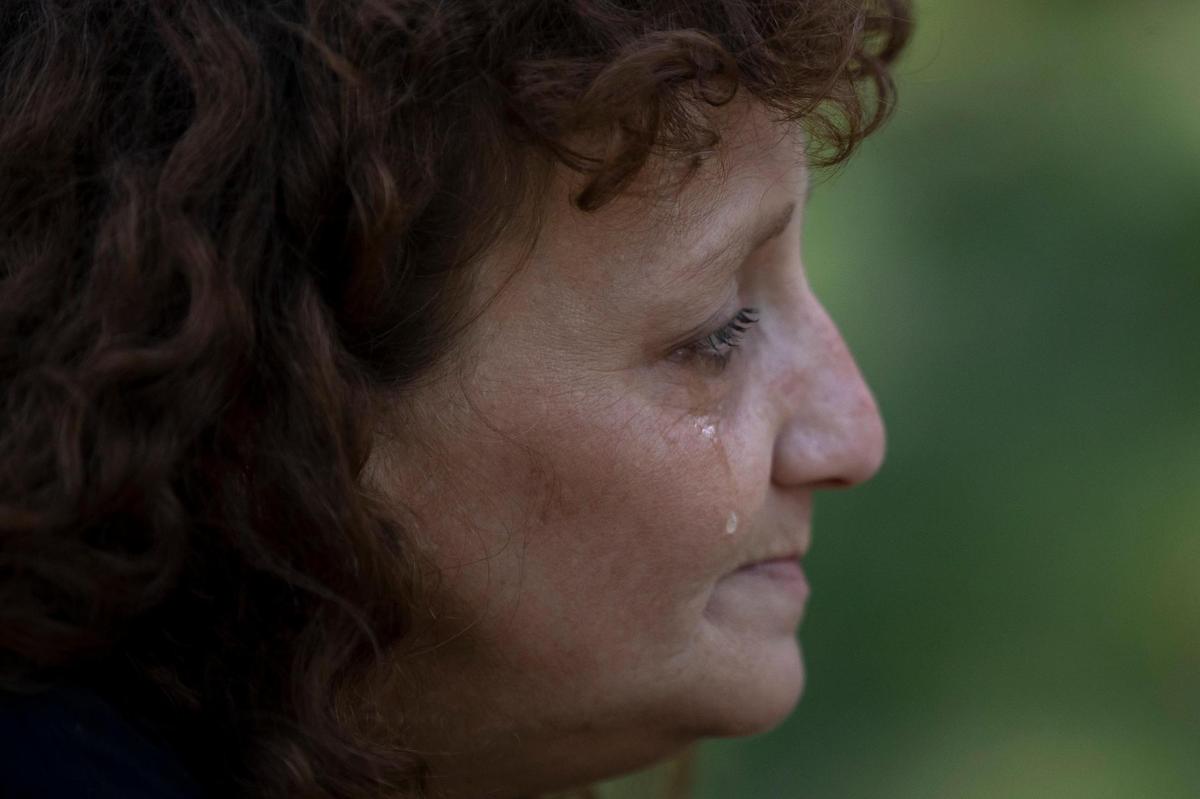 A tear runs down Angela Cornett’s cheek as she stands by a tent outside her home that was damaged by flooding last month in Perry County, Kentucky. Cornett lived in the house with her boyfriend, John Jones. They crawled out a window and up a hill behind the house to escape the flood.