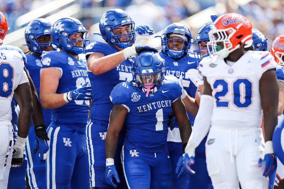 Kentucky running back Ray Davis (1) celebrates one of his four touchdowns with his teammates in Saturday’s win against Florida.