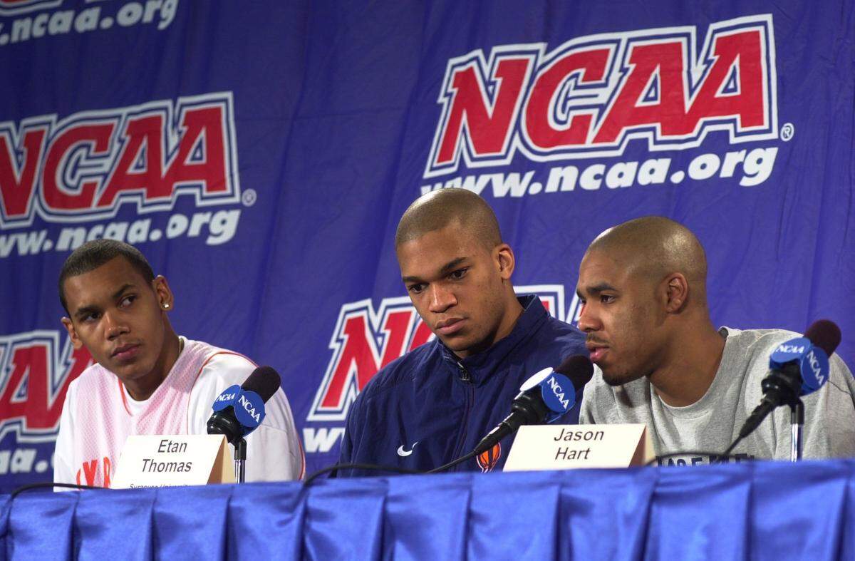 Jason Hart, right, sits with his Syracuse teammates and speaks at an NCAA Tournament podium before the team’s game against Kentucky in 2000. The Orange won the game, 52-50, eliminating the Wildcats in the second round.