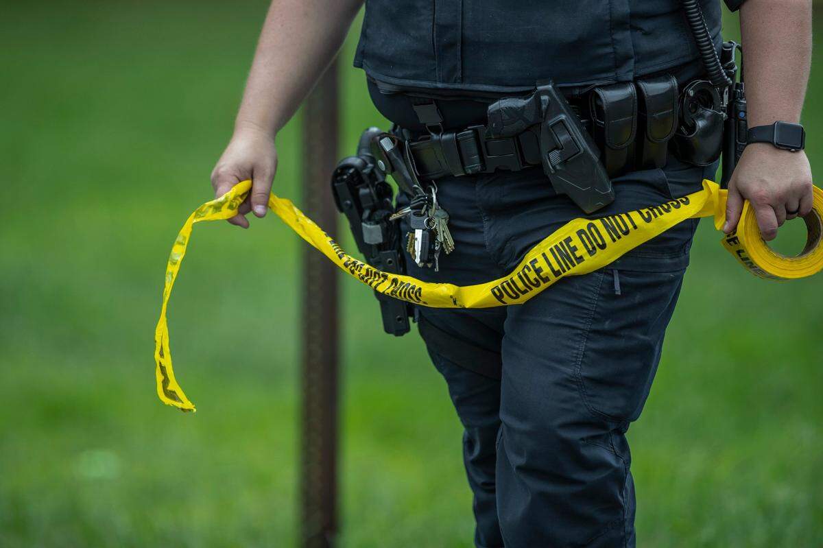 A Murray State University police office places police tape near the intersection of Poplar Street and Brentwood Avenue in Murray, Ky., on Saturday, Sept. 10, 2022. According to the Kentucky State Police, a man threw a Molotov cocktail style explosive in the direction of a group of female Murray State University students earlier in the day.