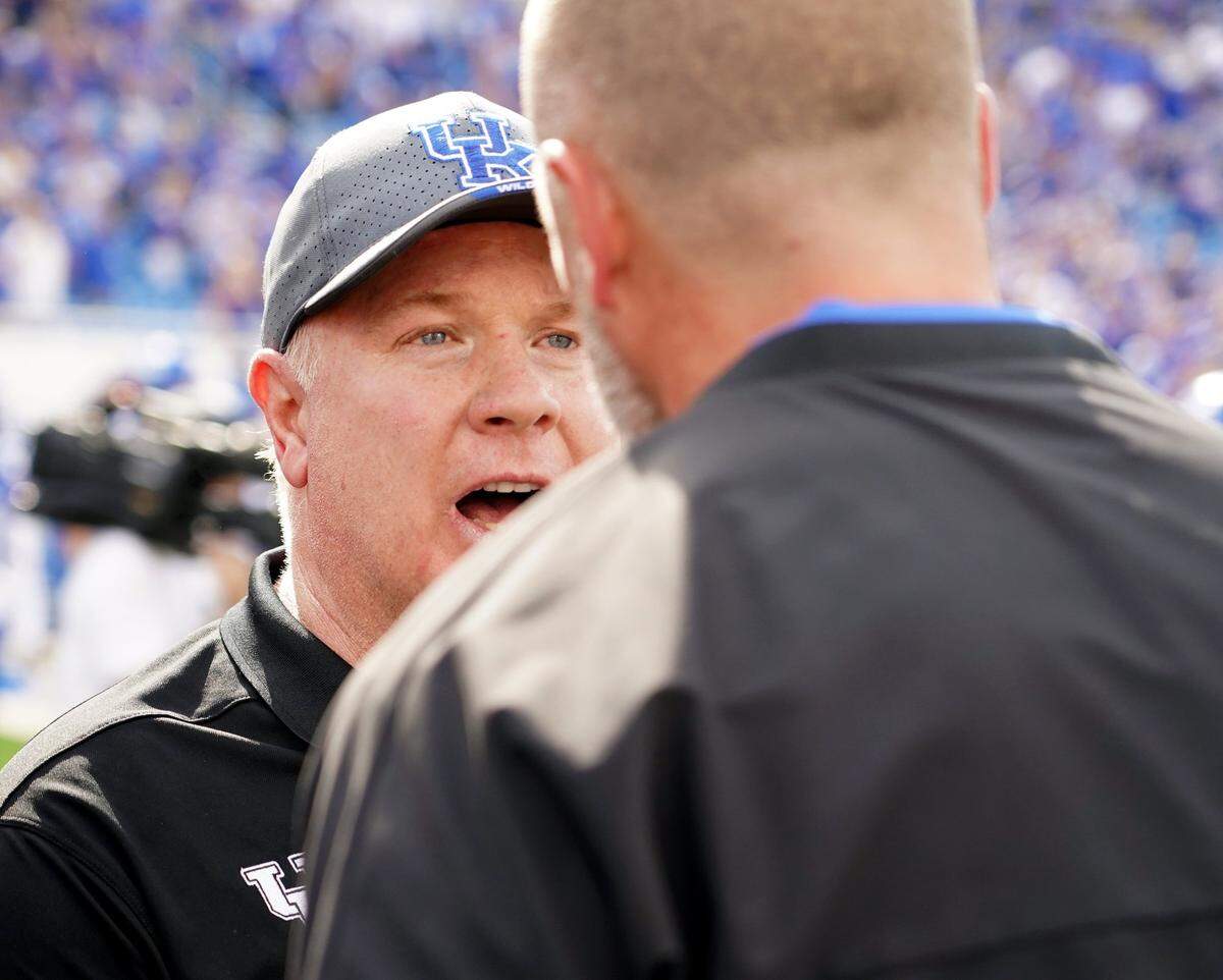 Kentucky coach Mark Stoops, left, met Florida head man Billy Napier following UK’s 33-14 win over the Gators last season at Kroger Field. Stoops and Napier will match wits again Saturday night in Gainesville as the Wildcats seek to extend their winning streak over Florida to four games in a row.
