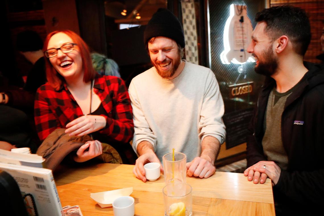 From left, Kelsey Bolger, Daniel Reed and Zach King laugh over drinks Feb. 29 at Standing Room Only in Lexington. SRO is a classic Japanese izakaya, a kind of tapas bar where people come in to drink, eat a bit, talk with friends and meet new people. It has no seats.