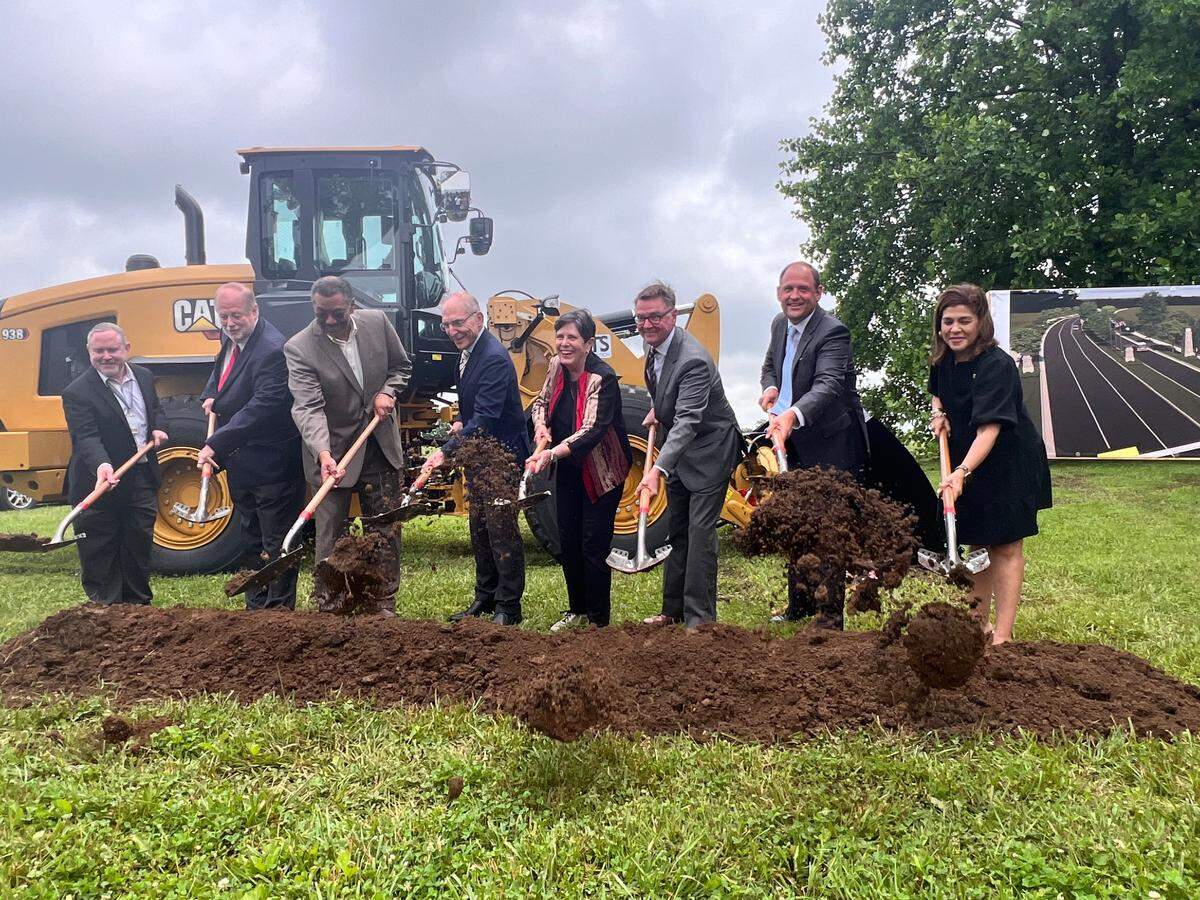 City and state leaders turn dirt in front of construction machinery during the groundbreaking ceremony at the new Legacy Business Park on June 18, 2025, in Lexington.