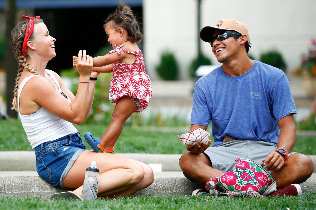Shelby Taylor, left, laughed with her daughter Chole Taylor-Jimenez, 1, and husband Javier Jimenez, all of Lexington, during the city’s Fourth of July festival in front of the old Fayette County courthouse Thursday.