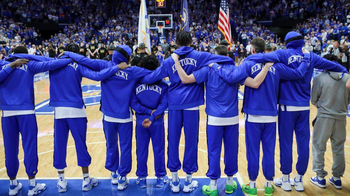 The Kentucky Wildcats link arms for the national anthem before their final home game of the 2022-23 season.