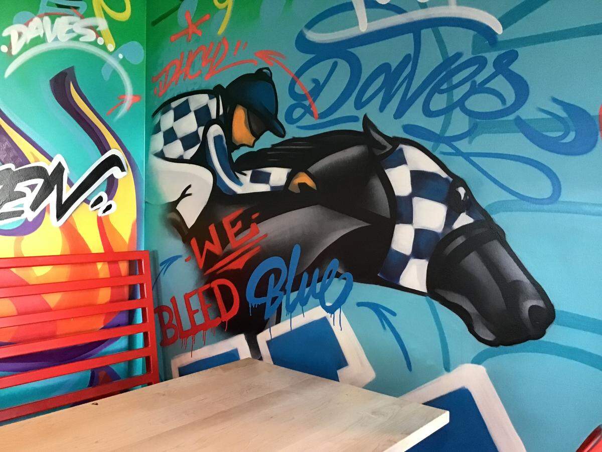 A mural inside the new Dave’s Hot Chicken at 2630 Richmond Rd. pays tribute to Kentucky’s racing traditions as well as the University of Kentucky.