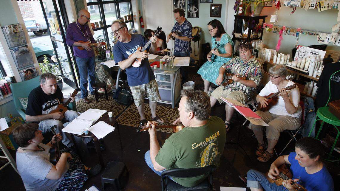 Mick Jeffries, standing, played with the all-ukelele group the Lexingtones at The Hive salon in Lexington. The group frequently likes to tackle pop and rock songs.